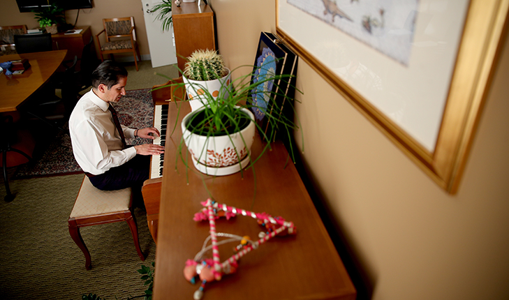 (New Provost Saúl Jiménez-Sandoval started playing the piano four years ago. He plays in this office to collect this thoughts. Photo by University photographer Cary Edmondson.)