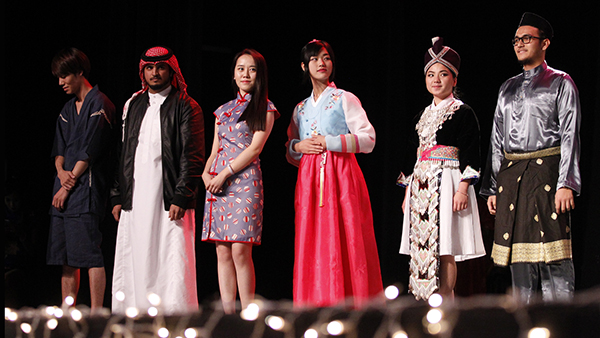 Students on stage in attire from their culture.