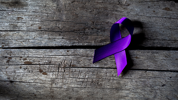 A piece of wood with a purple ribbon on it.