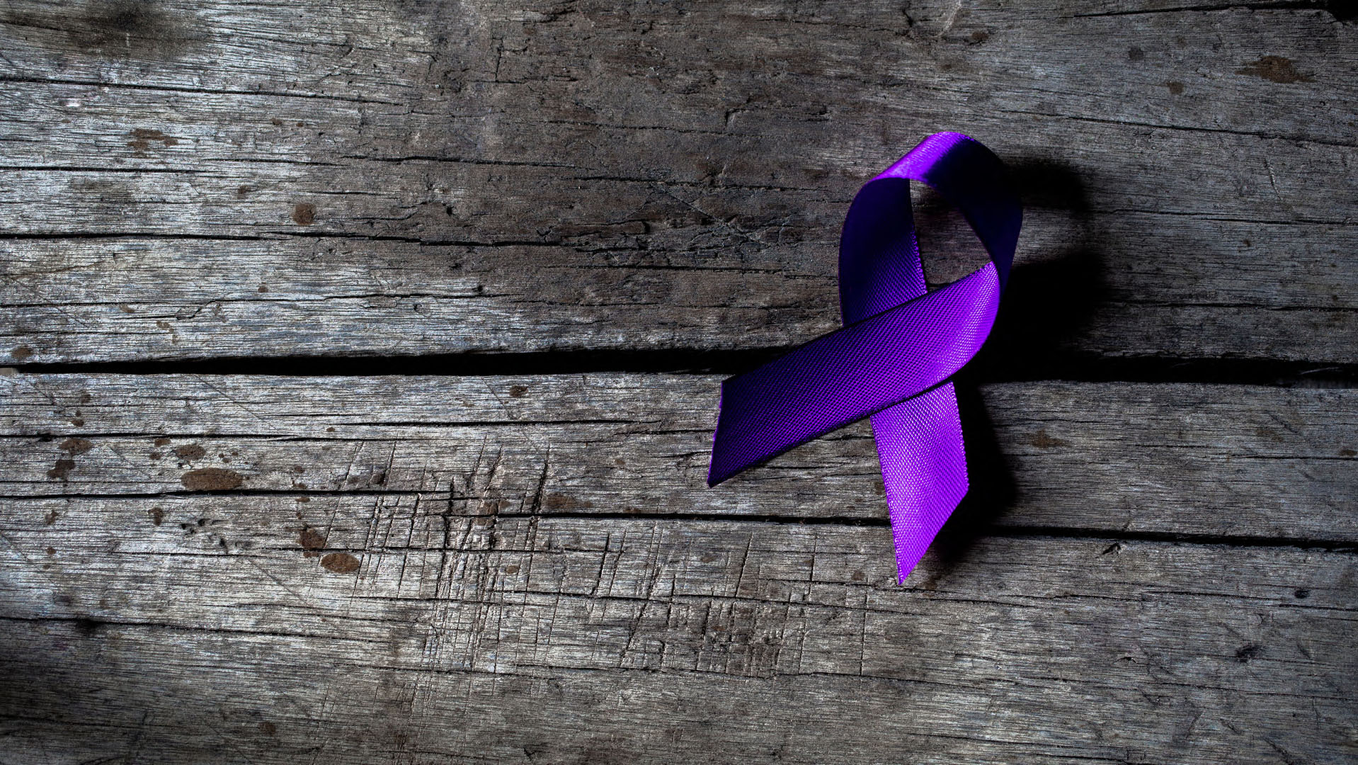 Purple ribbon on a piece of grey wood