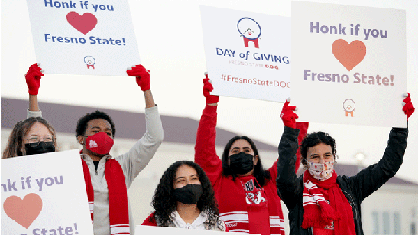 Students holding "honk if you love Fresno State" signs on the annual Day of Giving.