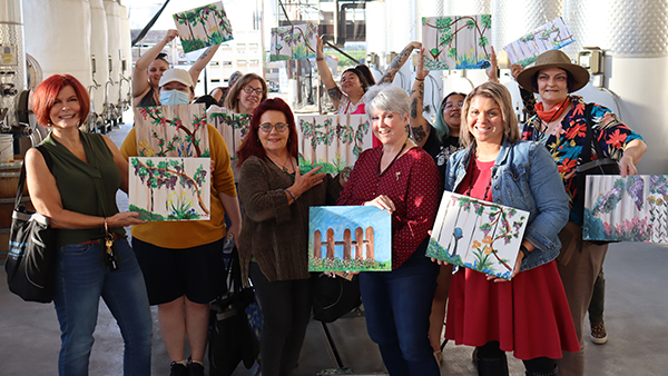 Fresno State women veterans from TRIO hold their paintings from paint night.