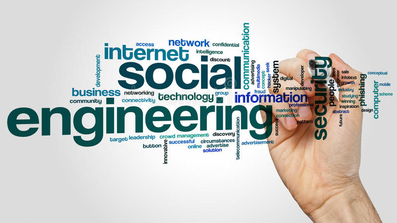 Social engineering word cloud with a hand and a pen writing