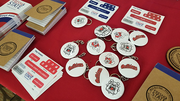 Fresno State Bulldog buttons and notepads on a red tablecloth.