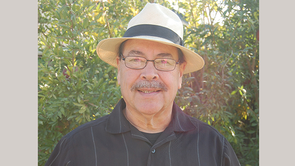 Professor Phillip Gonzales smiling with a hat on.