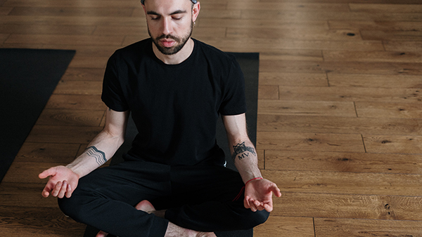 Man in meditation on yoga mat.