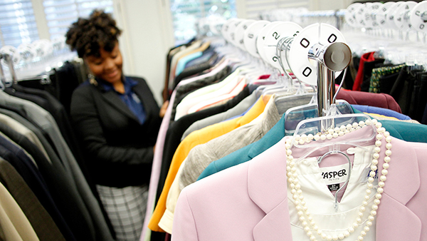 Black female student looking at clothes in the Clothing Closet.