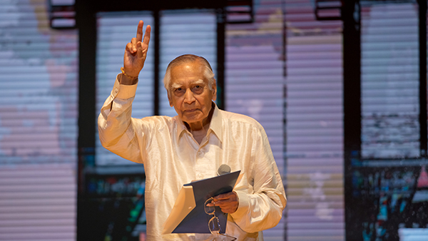 Dr. Surdashan Kapoor holds up a peace sign to receive the 2023 Lifetime Achievement Award at the Office of the Fresno County Superintendent of Schools' All Staff Day.