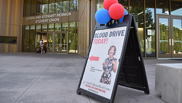Blood Drive Today sign with red and blue balloons in front of the Resnick Student Union.