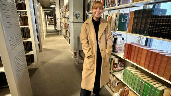 Taylor Peterson standing in front of books