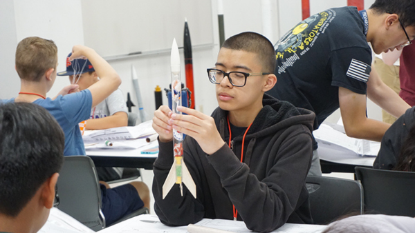 A young student works on a rocket.