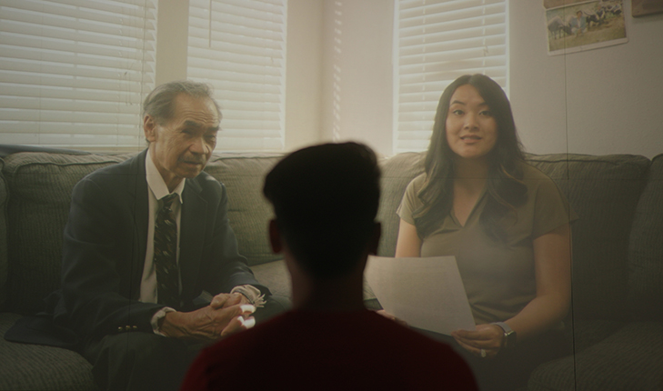 Parents on couch reading letter to son