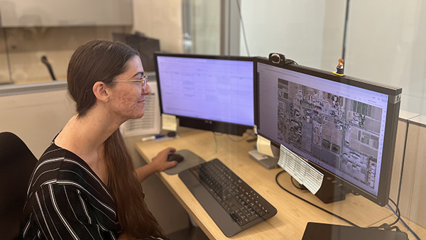 Woman looking at a computer with a map on the screen.