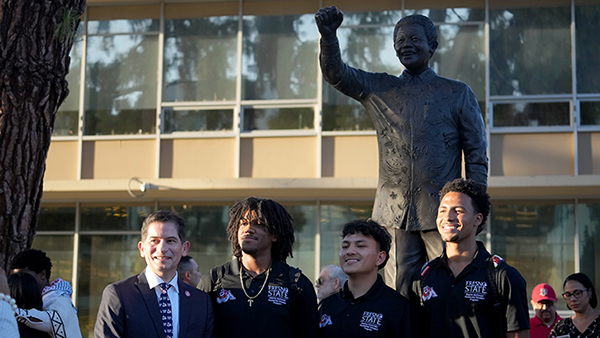 Nelson Mandela statue with students standing in front of it