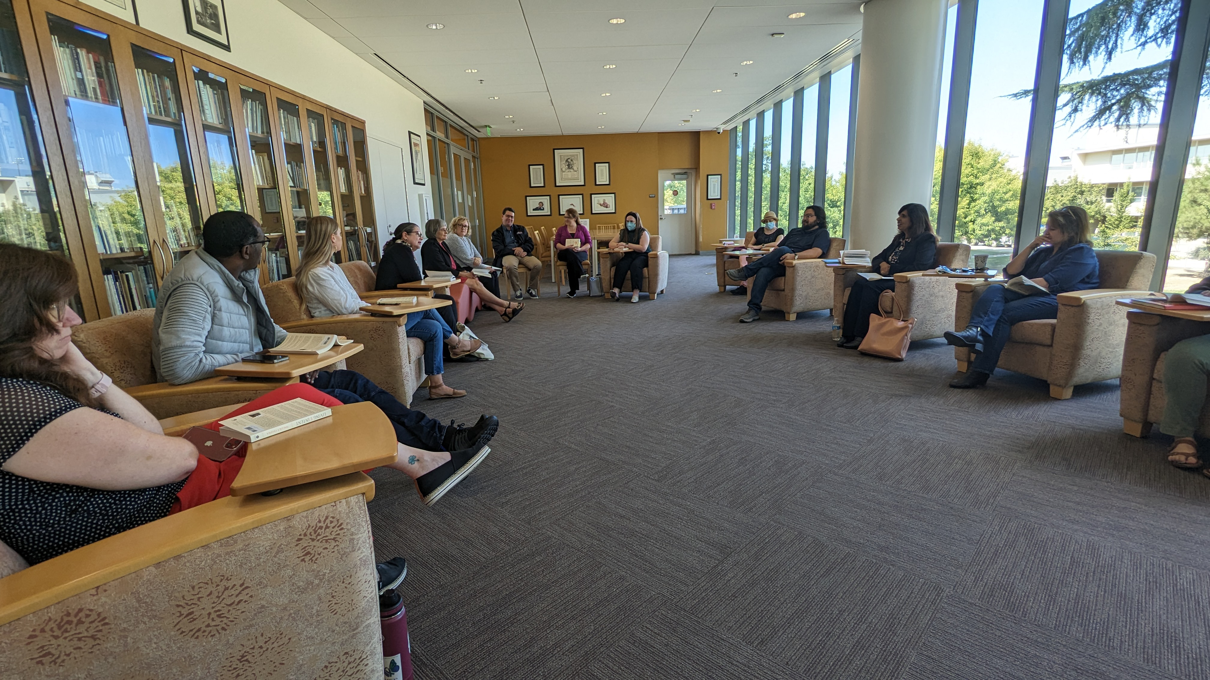 Employees in a circle discussing a book