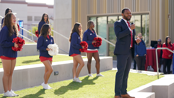 VP Kent Willis speaking at Red Friday with cheerleaders behind him