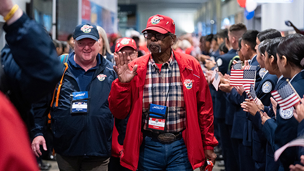 Navy veteran Joseph “Jay” Ventress  waves while walking next to Dean Scott Moore on their return to Fresno on the Honor Flight.