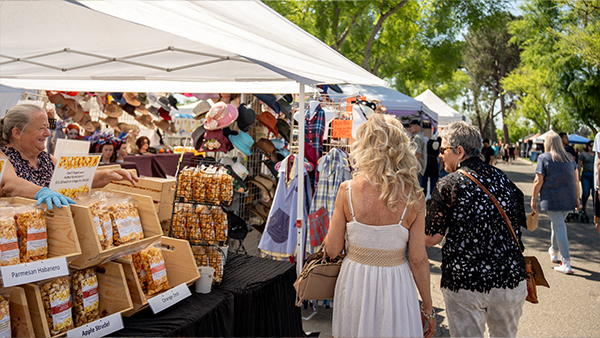 Visitors walking by a vendor selling popcorn at Vintage Days.