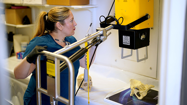 Dr. Chelsey Juarez uses a machine in the foresnic lab.