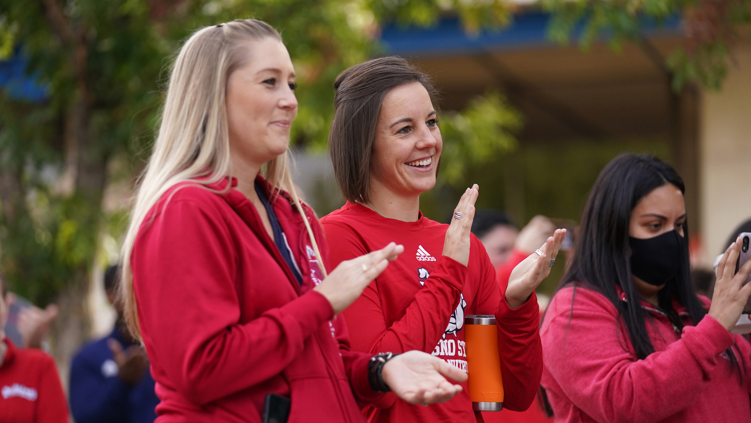 Women with red Fresno State T-shirts clap.