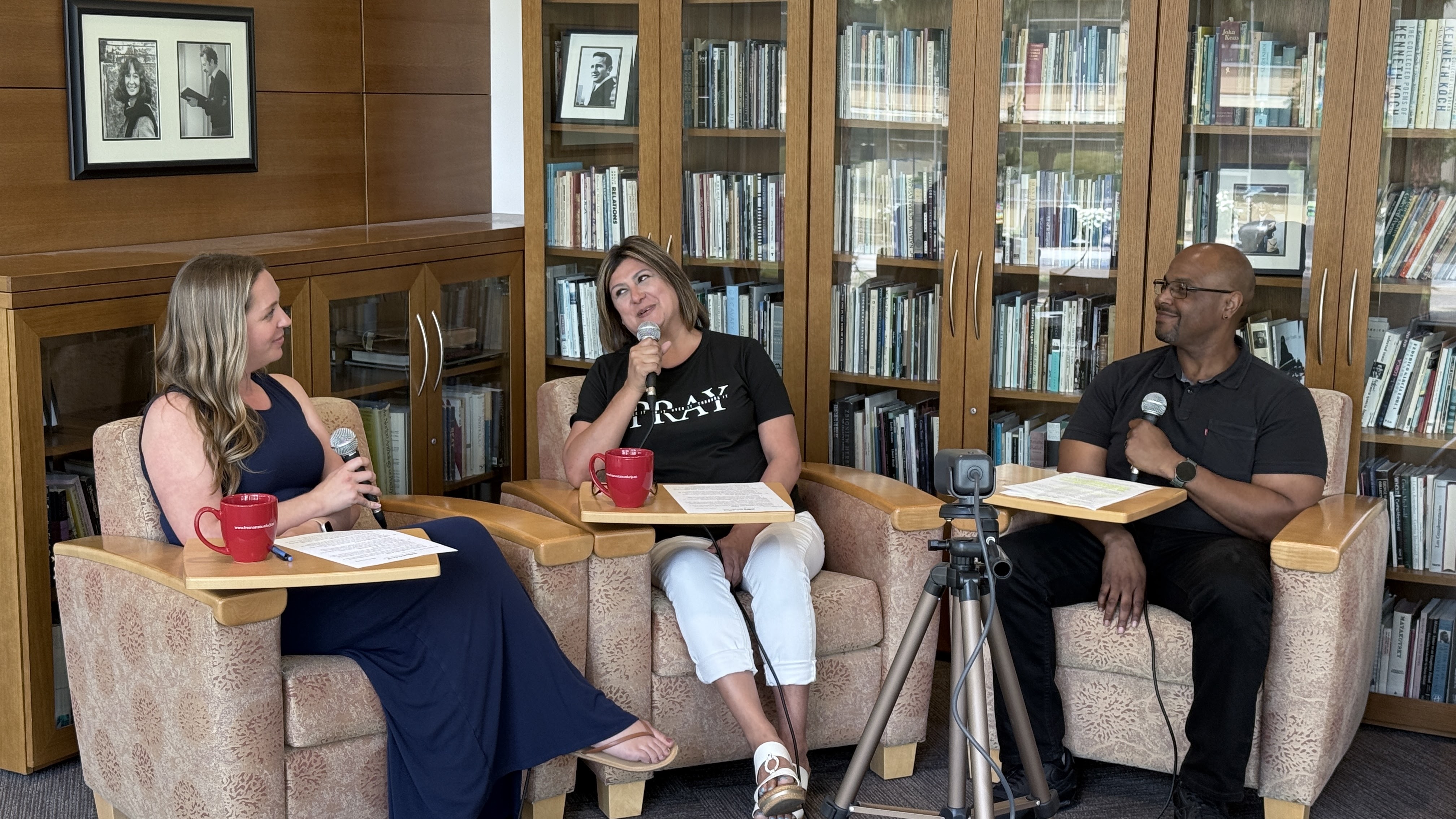 Melissa Norris (left) and Belinda Munoz, Staff Assembly podcast hosts, sit in chairs holding microphones to record the podcast with guest Zafar Sumler (right).