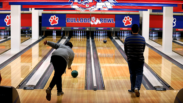 Two people bowl at Bulldog Bowl.