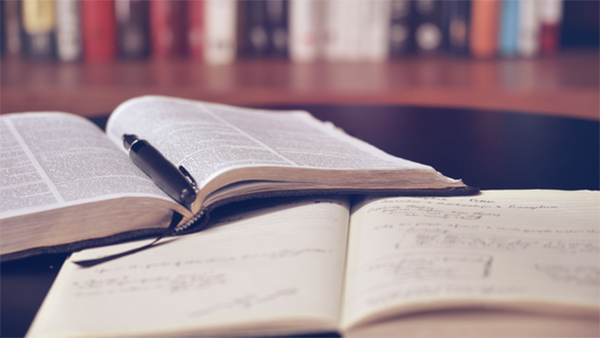 Books on a table with pen