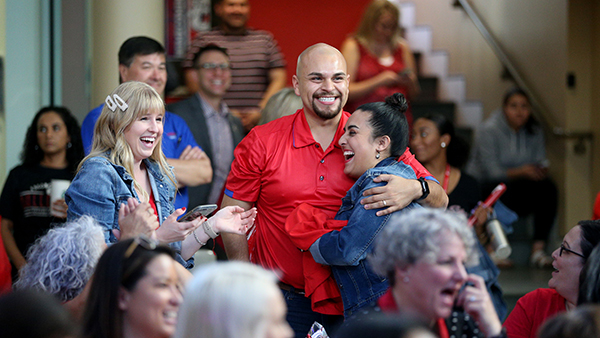 Faculty and Staff embracing one another at a Red Friday event
