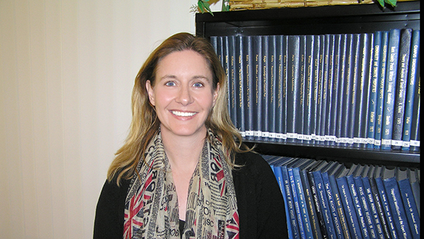 Dr. Emma Hughes in front of bookcase