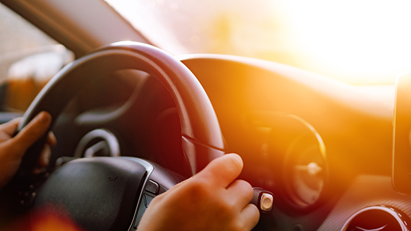 Hands on steering wheel driving.
