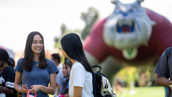 Two female students in front of the blow up Time Out dog