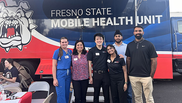 Dr. Nupur Hajela and physical therapy students in front of the Fresno State mobile health unit