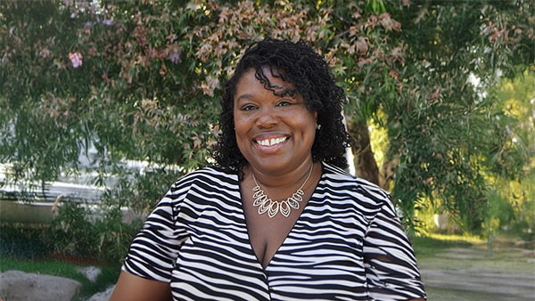 Portrait of Dr. Monique Bell in front of a tree.