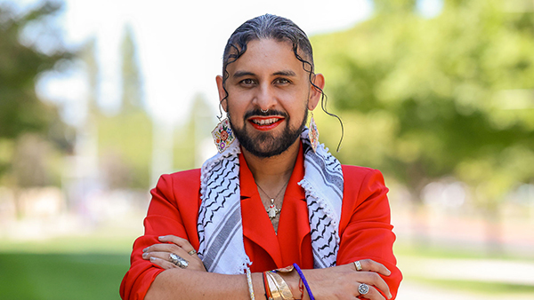 Portrait of Dr. Ángel de Jesus González in a red jacket, earrings and scarf.