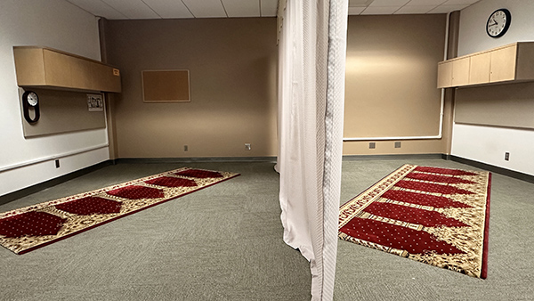 The Fresno State Library meditation room with two prayer rugs on the floor separated by a curtain.