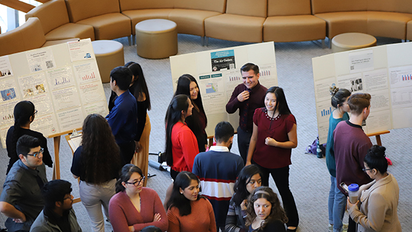 Students walking around presentation boards