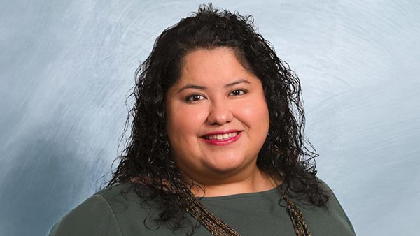 Portrait of Tania Pacheco-Werner in a green top and brown necklace.