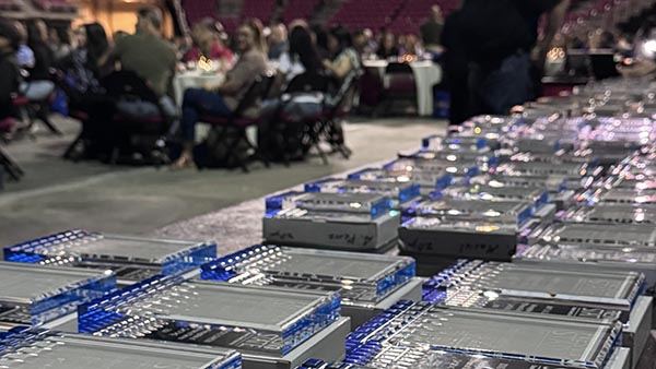 Staff recognition plaques on a table in the Save Mart Center.