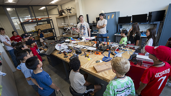 Fresno State students showing elementary students a drone.