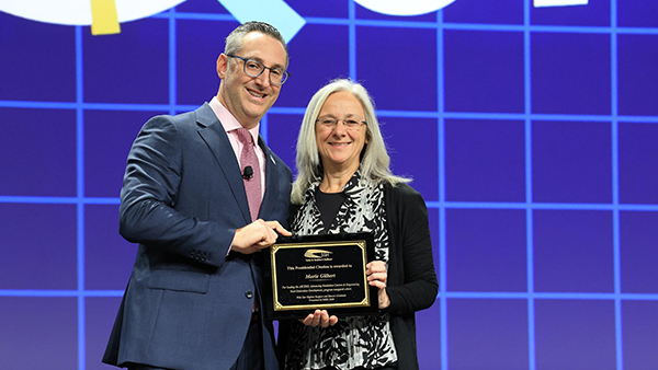 Dr. Marie Gilbert receiving award on stage