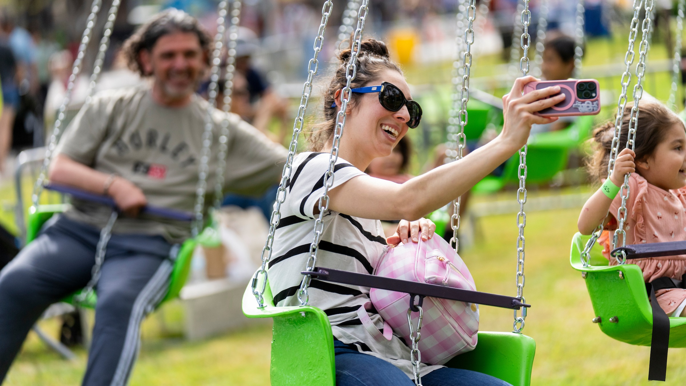 Woman holding a phone taking a selfie on carnival ride