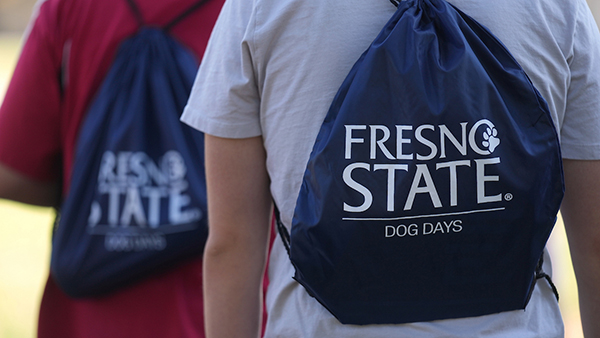 Students carrying Fresno State Dog Days drawstring bags