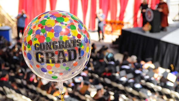 Clear balloon with confetti on it and writing that reads "Congrats Grad!"