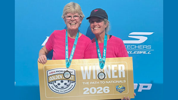 Katha Brassfield and friend wearing medals and holding a gold sign that says USA PickleBall Golden Ticket. Winner. The Path to Nationals 2026.