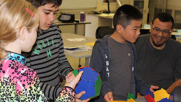 Three children attend a Math Circle event. The instructor is on the right.