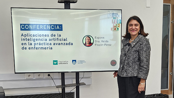 Dr. Helda Pinzon-Perez stands next to a screen with her presentation displayed on it.