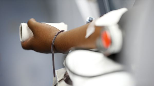 An outstretched arm giving blood.