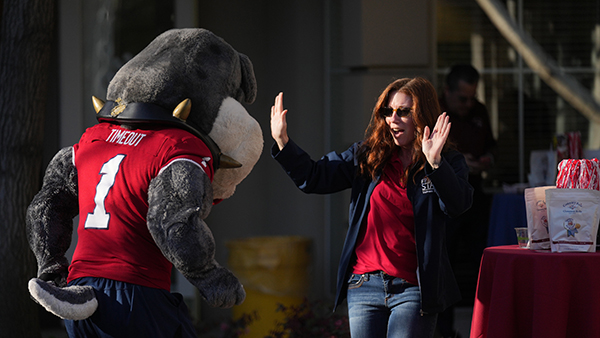 Fresno State employee with both hands up ready to high five TimeOut.