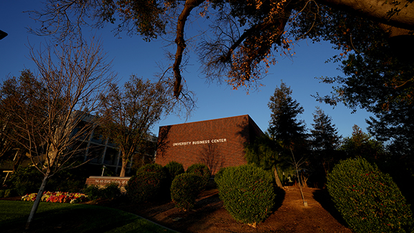 University Business Center with lots of trees and bushes surrounding it.