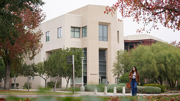 Female student walks in front of the Science II building at Fresno State.